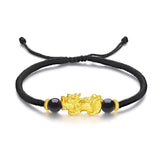 Gold Pixiu wealth attraction bracelet with black cord for men and women, featuring a gold plated charm for prosperity
