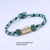 Green string bracelet with silver mantra charm for attracting luck and good fortune, a spiritual energy accessory for men and women.