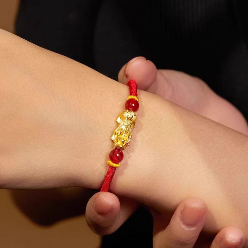 Gold Pixiu bracelet with red string for wealth attraction, featuring a gold-plated charm and beaded design for men and women.