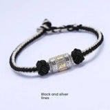 Silver mantra charm on black beaded string bracelet for luck attraction, symbolic energy flow jewelry