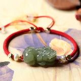 Green Jade Pixiu bracelet for wealth attraction, featuring a beaded design with red string and pearl accents for symbolic energy flow.