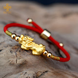 Wealth attraction bracelet with a silver and gold plated Pixiu charm on a classic red string design.