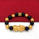 Men's black bead bracelet with a gold-plated Pixiu charm, a symbolic accessory for attracting wealth and prosperity