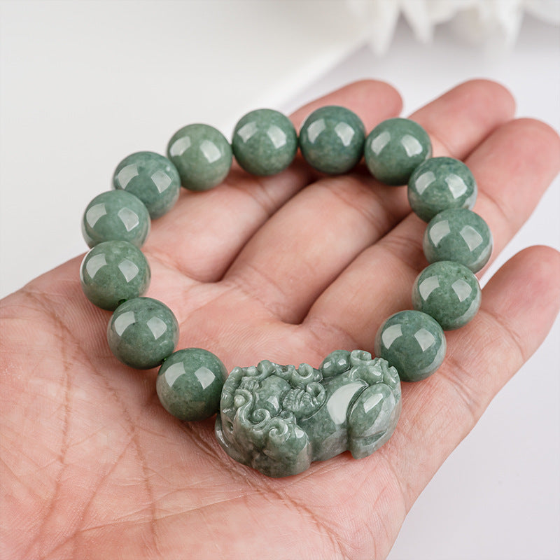 Women's green jade bracelet with Pixiu for wealth manifestation, a beaded stone accessory with energy symbolism