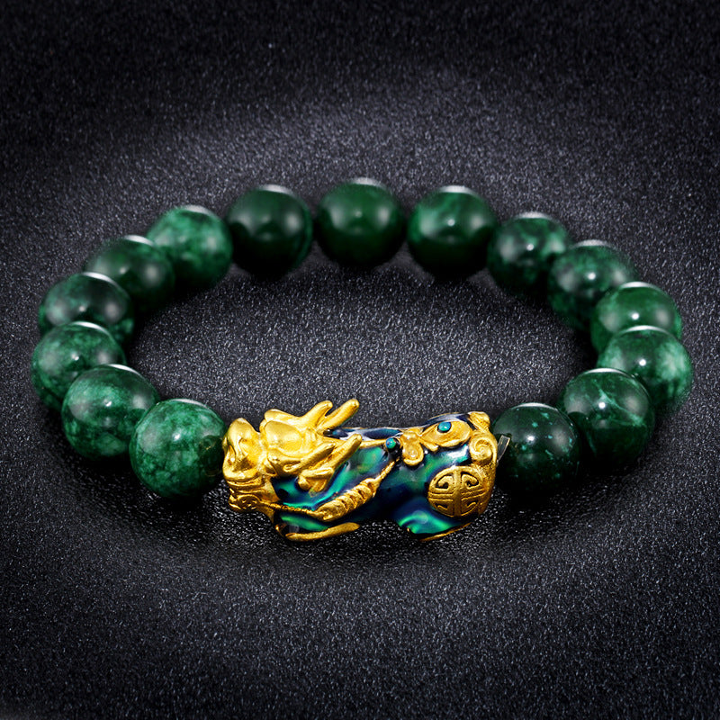 Green jade and color-changing stone bracelet with gold plated Pixiu charm, a Feng Shui accessory for wealth manifestation.