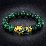 Green jade and color-changing stone bracelet with gold plated Pixiu charm, a Feng Shui accessory for wealth manifestation.