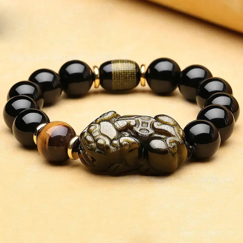Black Obsidian Pixiu charm bracelet with gold plated accents for wealth manifestation, beaded spiritual accessory