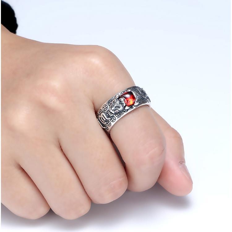 Silver ring featuring a Pixiu charm and red garnet stone for wealth manifestation