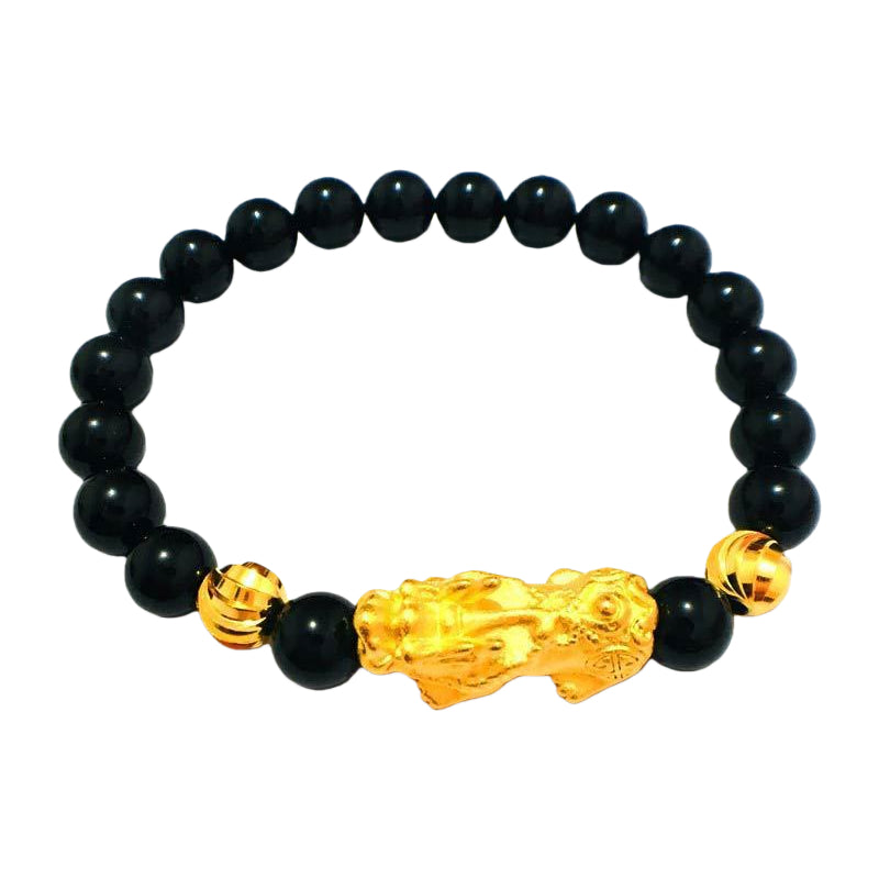 Gold plated Pixiu charm on a black agate beaded bracelet, a feng shui accessory for wealth manifestation and energy flow.