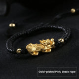 Silver Pixiu wealth bracelet with gold plated charm on black string, symbolic for attracting wealth and prosperity.