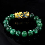 Feng Shui wealth bracelet featuring a green jade stone beaded design and a prominent gold plated Pixiu charm.