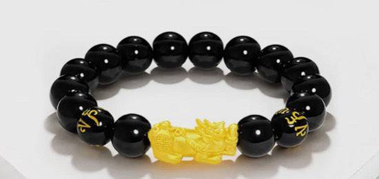 Feng shui black bead bracelet for men, featuring a prominent gold-plated Pixiu charm to attract wealth
